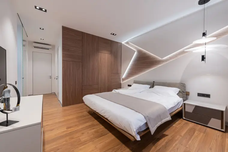 Bedroom with pale luxury vinyl plank flooring and white bedding