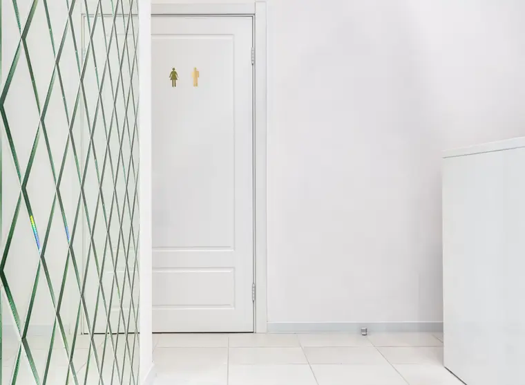 Empty hallway with a tiled floor and a white door