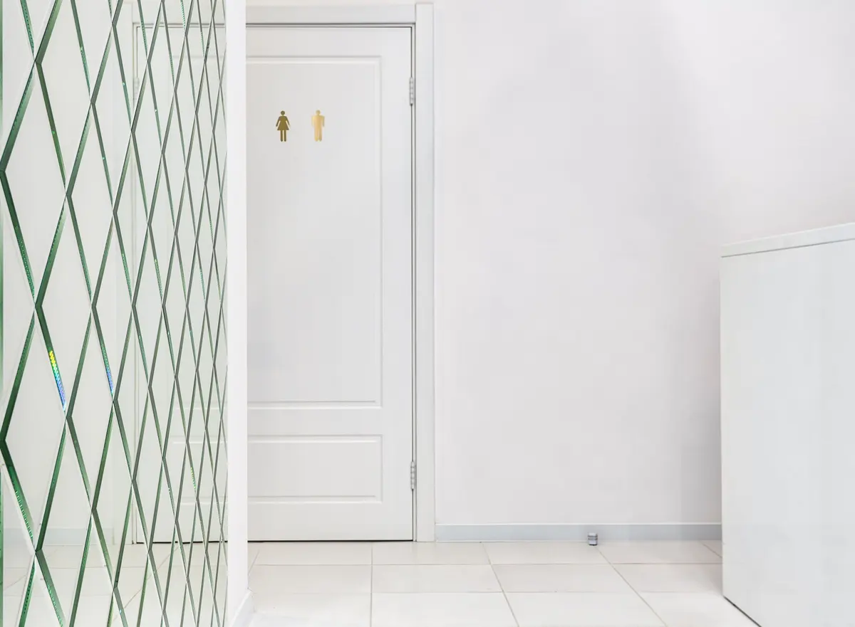 Empty hallway with a tiled floor and a white door