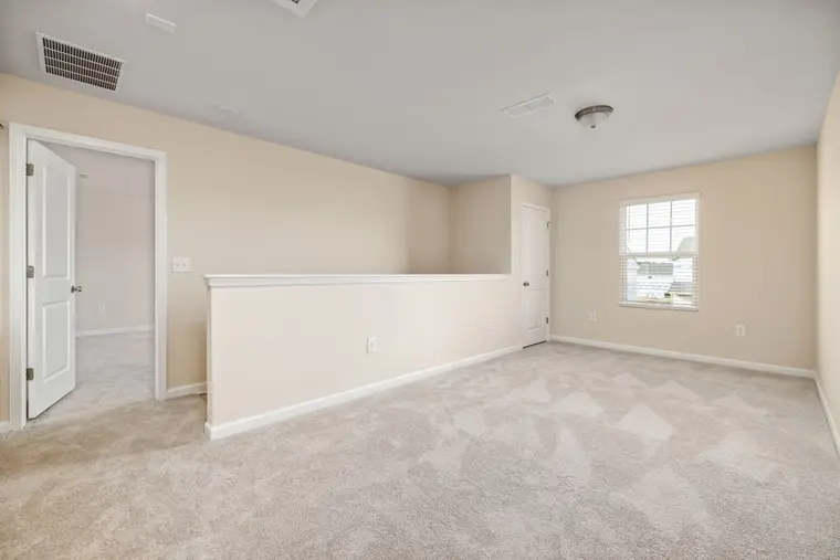Newly carpeted room with beige walls, ready for furniture to move back in