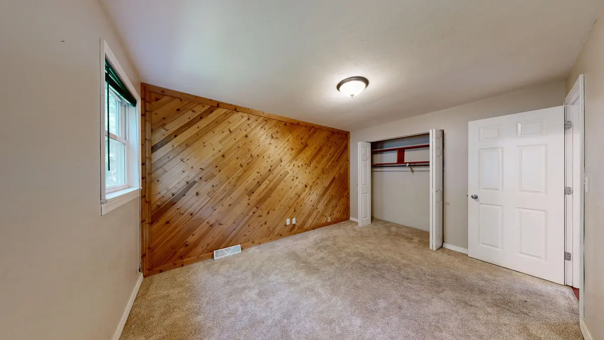 Carpeted room with a wooden accent wall