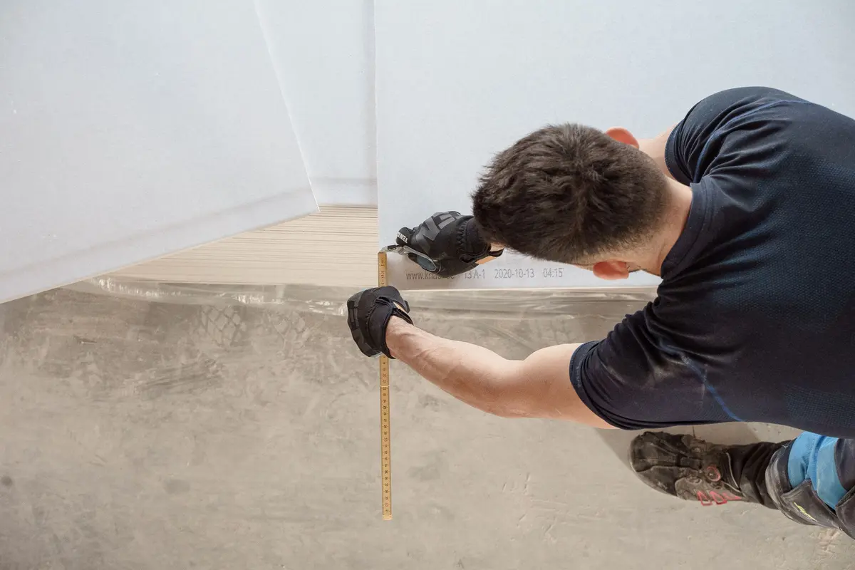 Installer measuring and cutting flooring on site