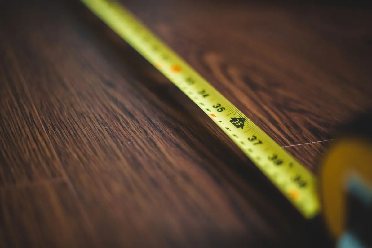 Tape measure extended across a bare timber subfloor