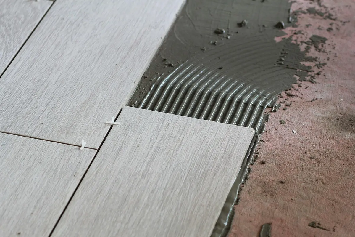 Floor tiles being bedded into place during an installation