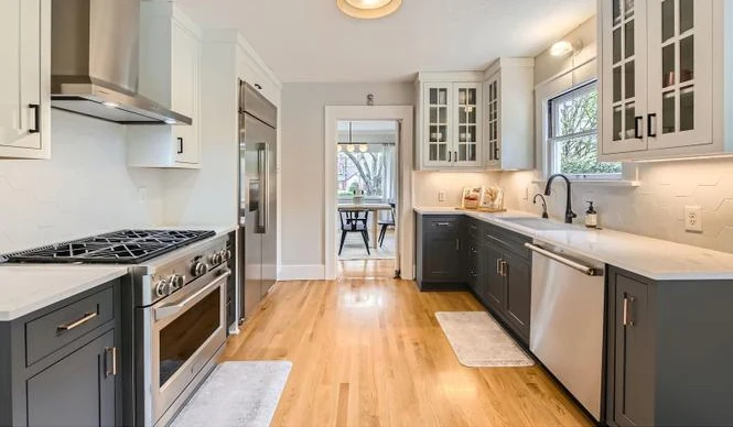 Galley kitchen with quartz counters and a white oak floor
