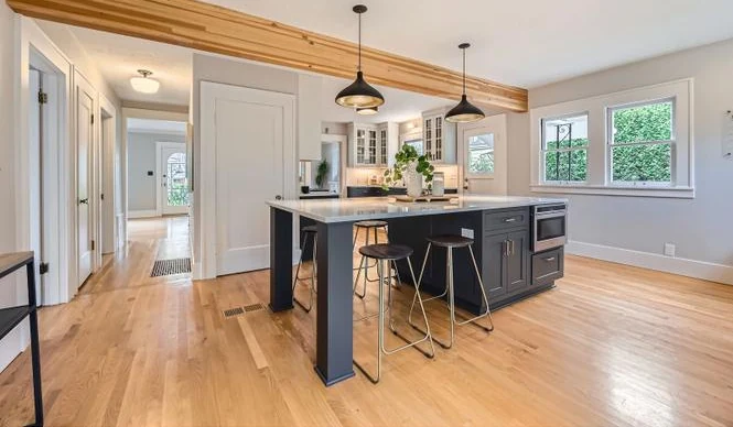 Open-plan kitchen with a hardwood floor running through to the hallway