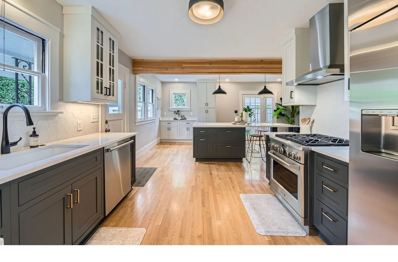 Galley kitchen with white oak flooring, quartz counters and a cedar beam