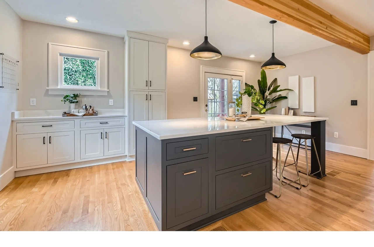 Two-tone kitchen with a gray island, quartz counters and wood-look plank flooring