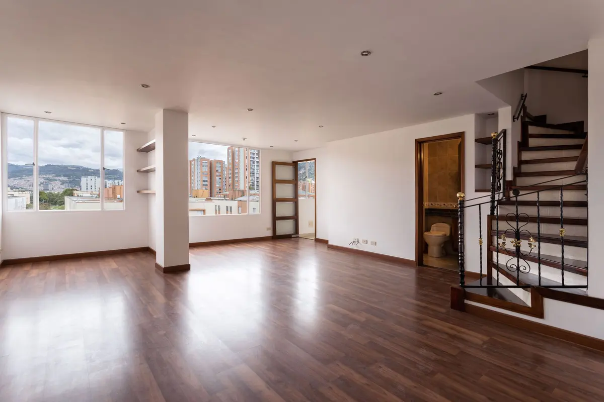 Living room with wood-look flooring running to the stairs