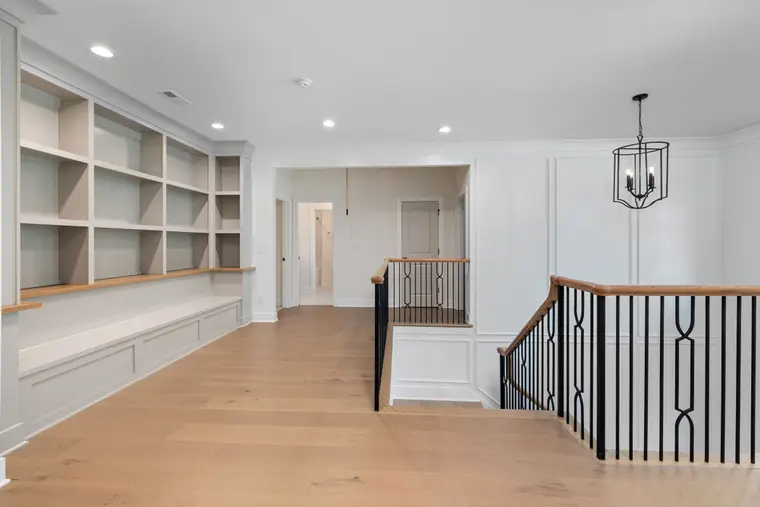 Entrance foyer with wood-look flooring and a custom staircase